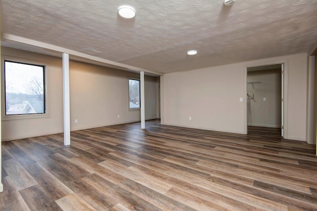 basement featuring dark hardwood / wood-style floors and a textured ceiling