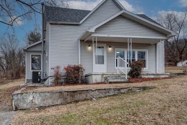 view of front facade featuring a porch, central AC, and a front yard