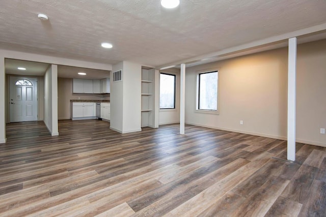 basement featuring dark hardwood / wood-style floors and a textured ceiling