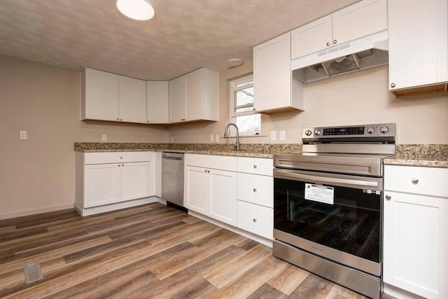 kitchen featuring wood-type flooring, appliances with stainless steel finishes, sink, and white cabinets