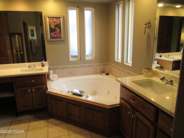 bathroom with a washtub, vanity, and tile patterned floors