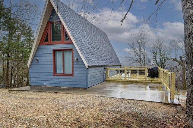 view of side of home featuring a deck and a patio