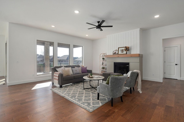 living room featuring dark wood-type flooring and ceiling fan