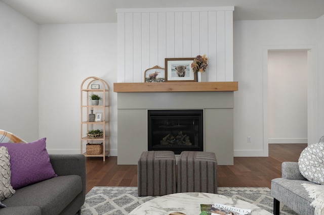 living room with a fireplace and dark wood-type flooring