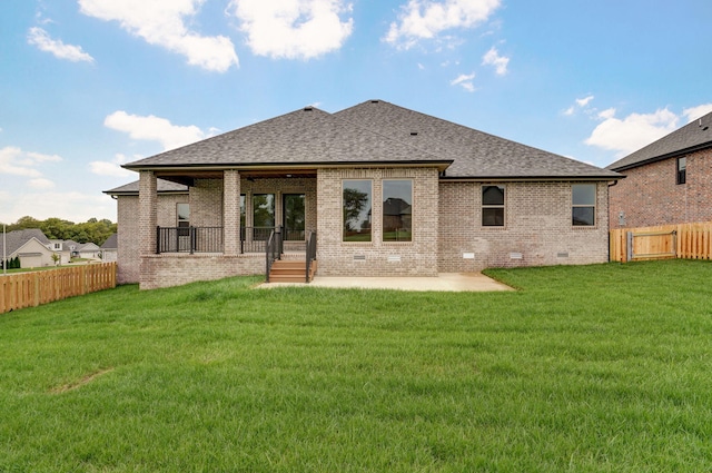 rear view of property with a yard and a patio area