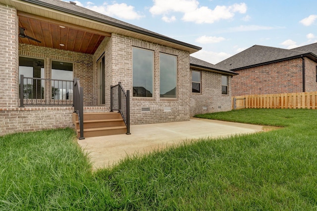 rear view of property with a patio, a yard, and ceiling fan