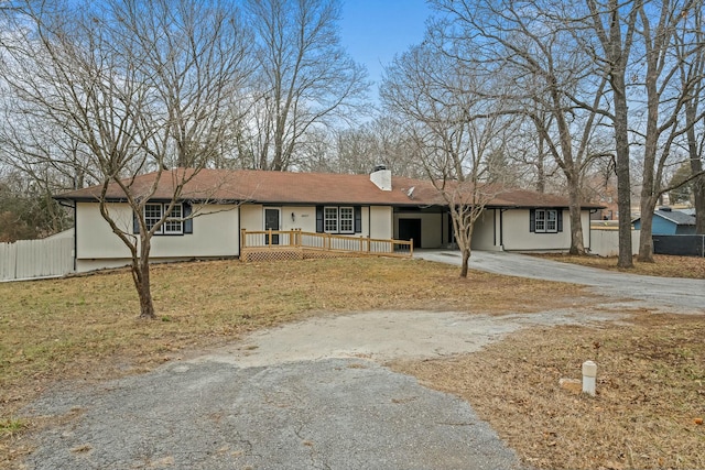 ranch-style home with a front lawn and a deck