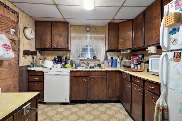 kitchen featuring dark brown cabinets, sink, and white appliances