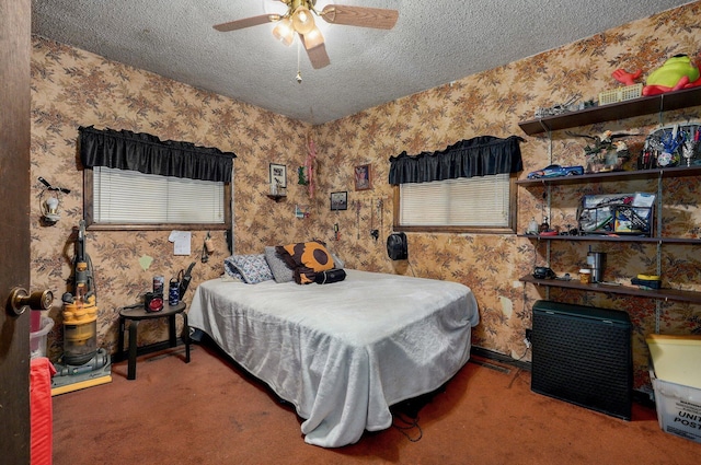 bedroom with ceiling fan, carpet floors, and a textured ceiling