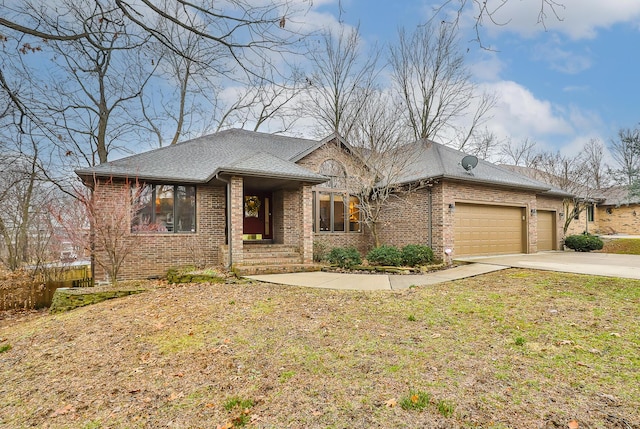 view of front facade with brick siding, an attached garage, driveway, and a front yard