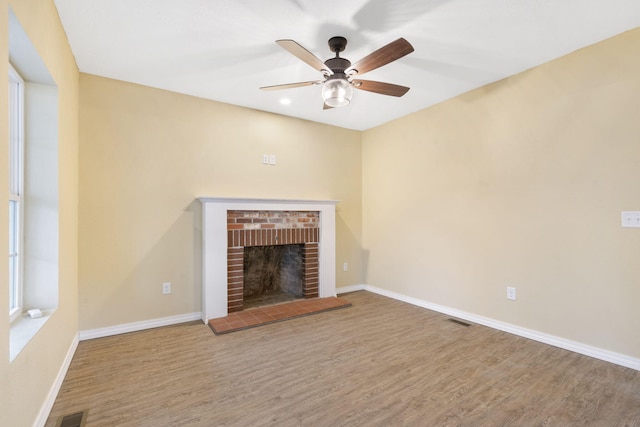 unfurnished living room with hardwood / wood-style flooring, a fireplace, and ceiling fan