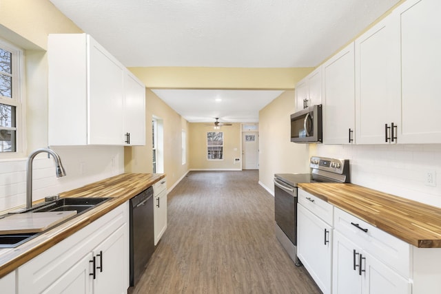 kitchen featuring butcher block counters, sink, stainless steel appliances, and white cabinets