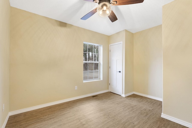 empty room with hardwood / wood-style flooring and ceiling fan