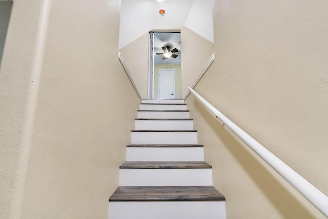 stairs featuring ceiling fan