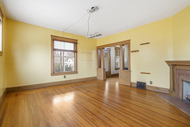 unfurnished living room with hardwood / wood-style floors and a high end fireplace