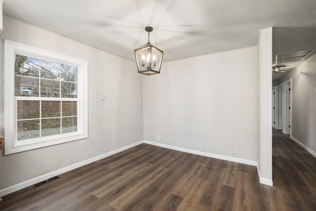 unfurnished dining area with dark hardwood / wood-style flooring and a notable chandelier