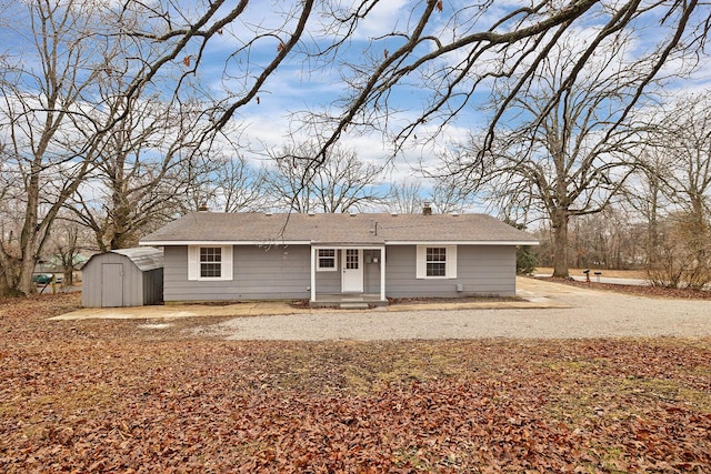rear view of property featuring a storage shed