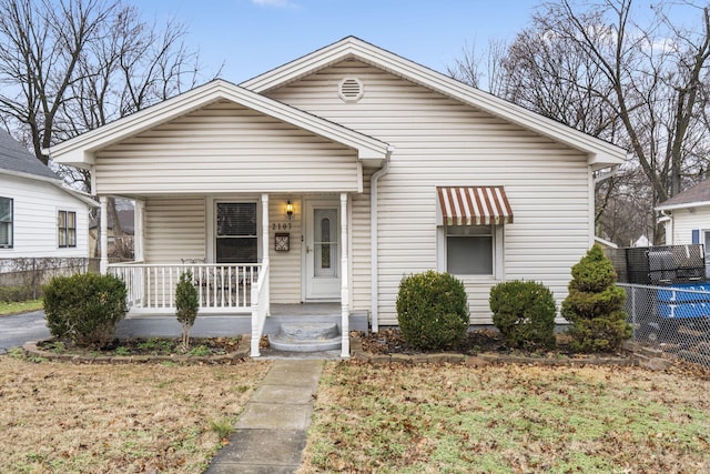 bungalow with covered porch and a front yard