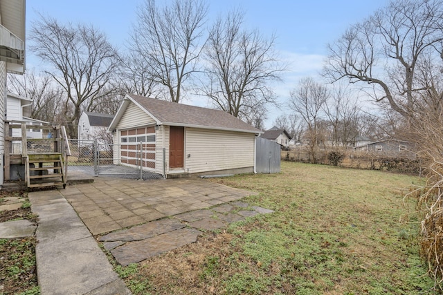 view of yard with a garage, an outdoor structure, and a patio