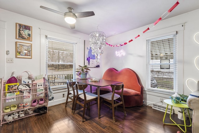 dining space featuring ceiling fan with notable chandelier and dark hardwood / wood-style floors