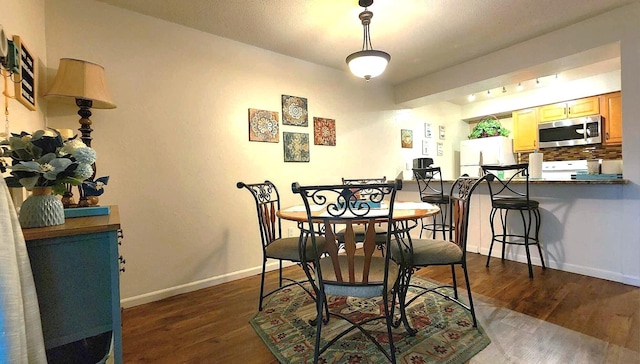 dining area with dark hardwood / wood-style floors