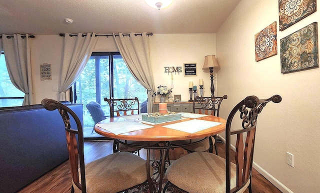 dining space with dark hardwood / wood-style floors and a textured ceiling