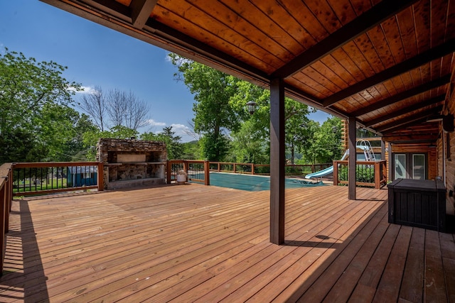 241 Nine Center Ct, Reeds Spring, MO 65737 - wooden deck with an outdoor stone fireplace and view of wooded area