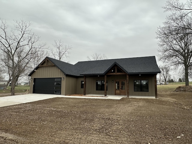 modern inspired farmhouse featuring french doors, a garage, roof with shingles, and driveway