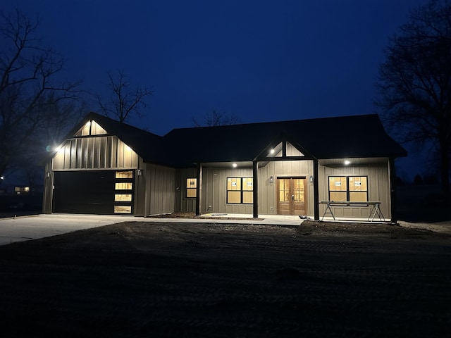 modern farmhouse with french doors, driveway, board and batten siding, and an attached garage