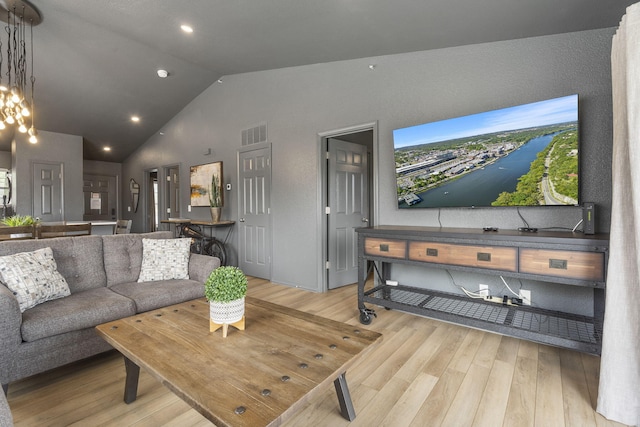 living room featuring vaulted ceiling and light hardwood / wood-style flooring