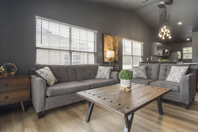 living room featuring high vaulted ceiling and light hardwood / wood-style flooring