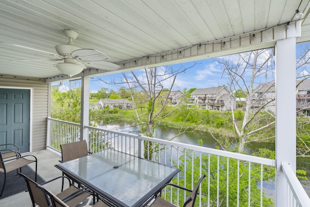 sunroom featuring a water view and ceiling fan