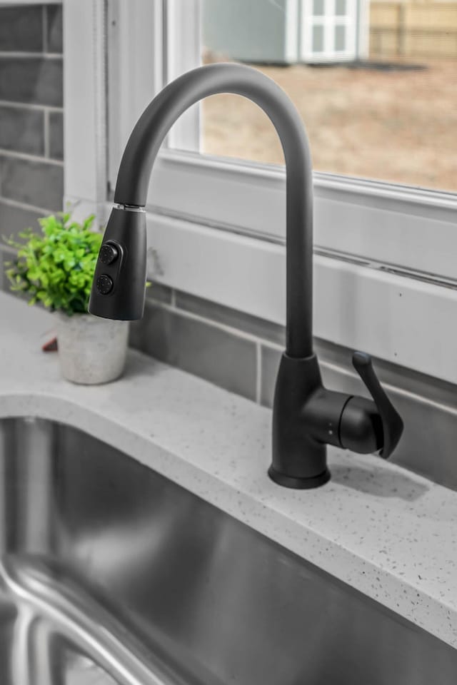 details with light stone countertops and a sink