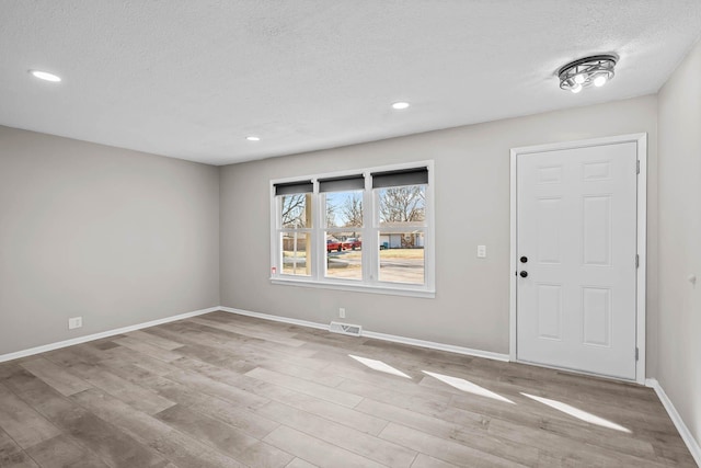 entrance foyer with visible vents, a textured ceiling, wood finished floors, recessed lighting, and baseboards