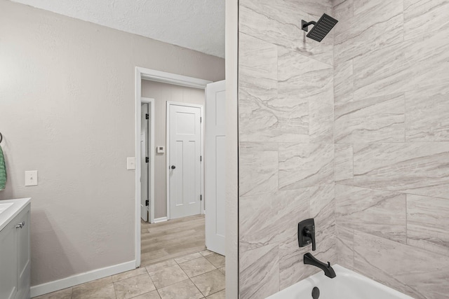 full bathroom with baseboards, vanity, shower / bath combination, a textured wall, and a textured ceiling