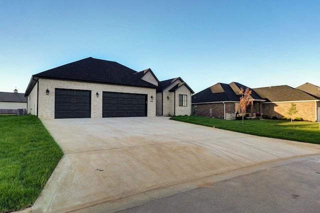 view of front facade featuring a garage, central AC unit, and a front yard