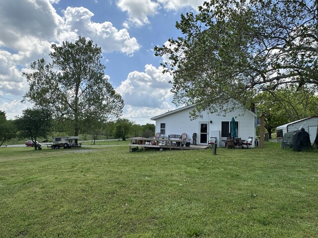 view of green lawn featuring a wooden deck