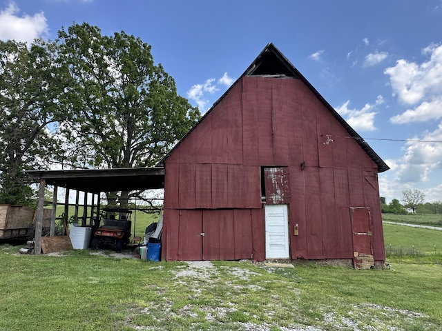 view of barn featuring a yard and a carport