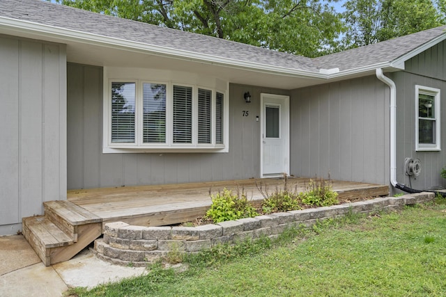 entrance to property with a yard and a deck