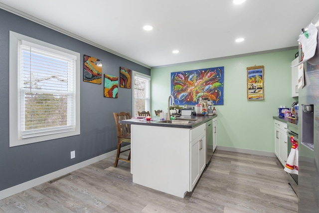 kitchen with sink, white cabinetry, crown molding, light hardwood / wood-style flooring, and kitchen peninsula