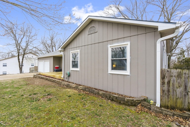 view of side of home with a garage and a lawn