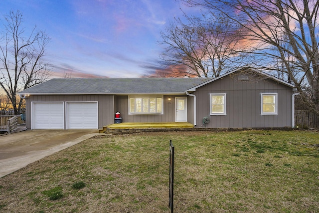 ranch-style home with a garage and a lawn