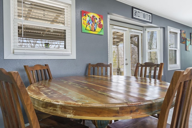 dining space with crown molding, a wealth of natural light, and french doors