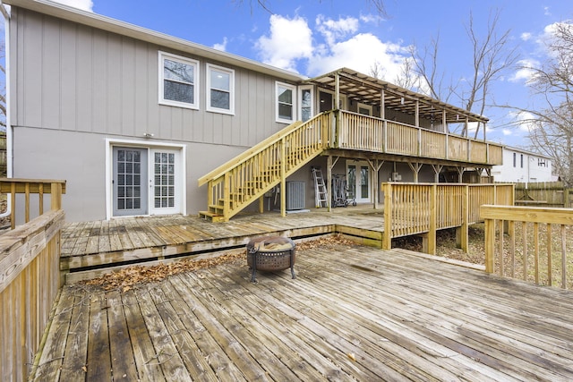 rear view of house featuring a fire pit, french doors, and a deck