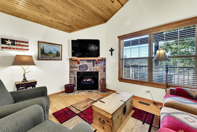 living room featuring light hardwood / wood-style floors, lofted ceiling, wooden ceiling, and a stone fireplace