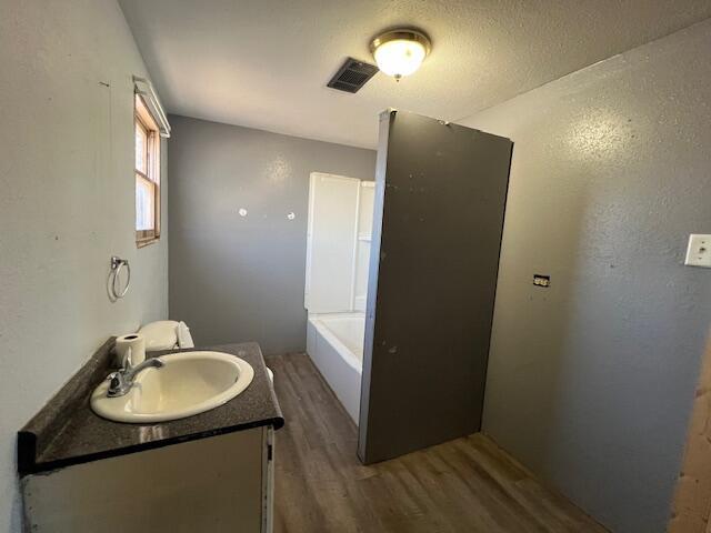 bathroom featuring vanity, hardwood / wood-style floors, and a bathtub