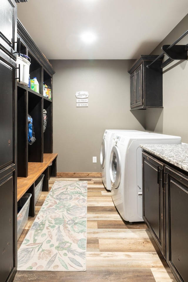 laundry area featuring cabinets, independent washer and dryer, and light wood-type flooring