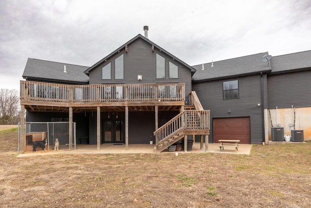 rear view of property with a wooden deck, a patio, and central air condition unit