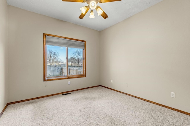 unfurnished room featuring ceiling fan and carpet