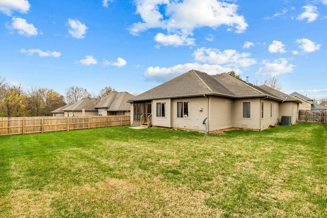 rear view of property with a lawn, a sunroom, and central air condition unit